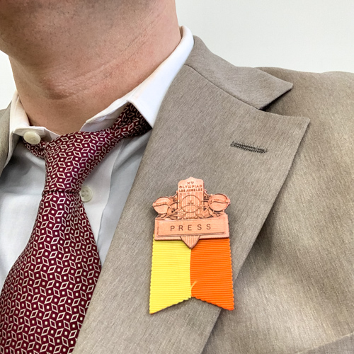 A reporters badge pinned to a jacket.