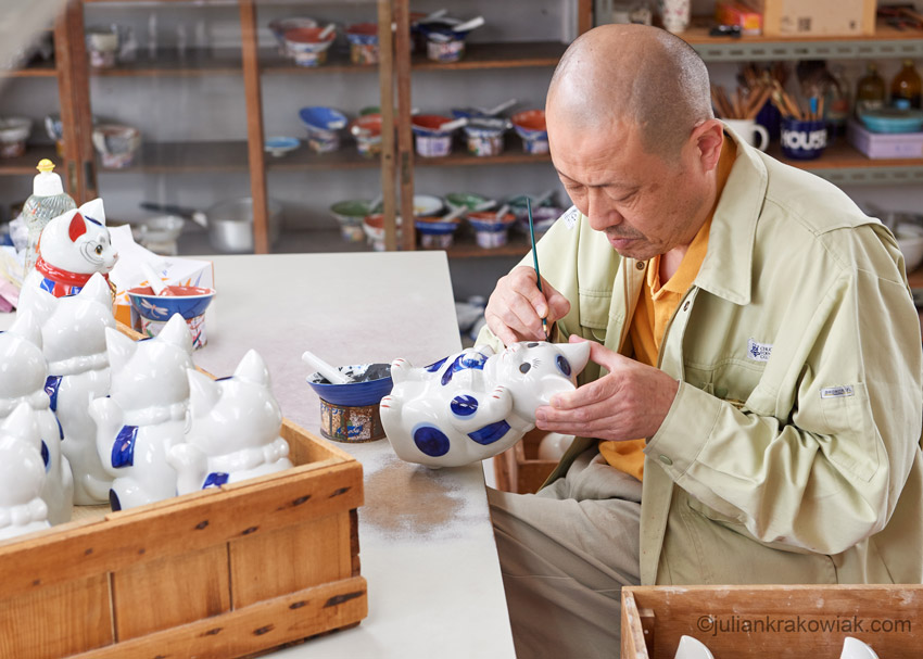 Artisan painting a pottery cat